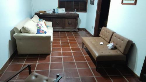 uma sala de estar com um sofá e uma cadeira em Quintal Amantikir em Queluz