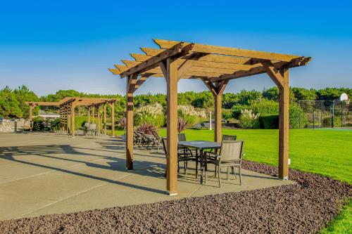 a wooden pergola with a table and chairs at Ocean Avenue Condos in Westport