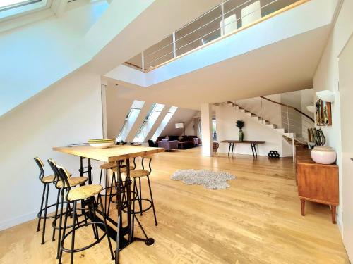 una sala de estar con mesa y taburetes en un loft en 3 bedrooms Penthouse with 3 Terraces & Free Parking-145--2, en Luxemburgo