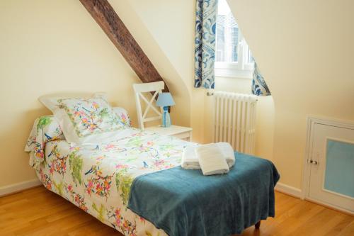 a bedroom with a bed and a staircase with blue curtains at RELAIS SAINT JACQUES in Amboise