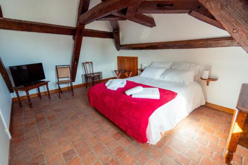 a bedroom with a large bed with a red blanket at RELAIS SAINT JACQUES in Amboise