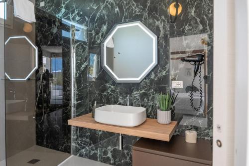 La salle de bains est pourvue d'un lavabo et d'un miroir. dans l'établissement Murieri Rooms, à Otrante