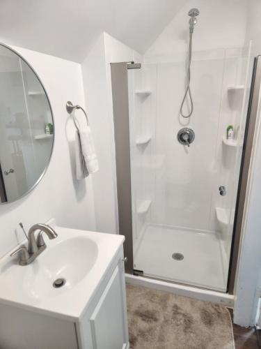 a white bathroom with a shower and a sink at Street side studio apartment in Manchester