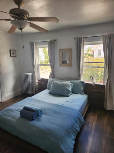 a bedroom with a large bed with a ceiling fan at Street side studio apartment in Manchester