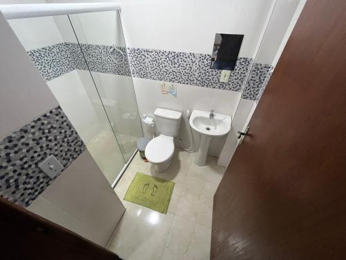 a bathroom with a toilet and a shower and a sink at Hotel Marquês de Maricá in Maricá