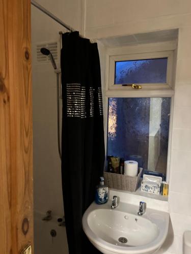 a bathroom with a sink and a black shower curtain at The Gallery in Middlesbrough