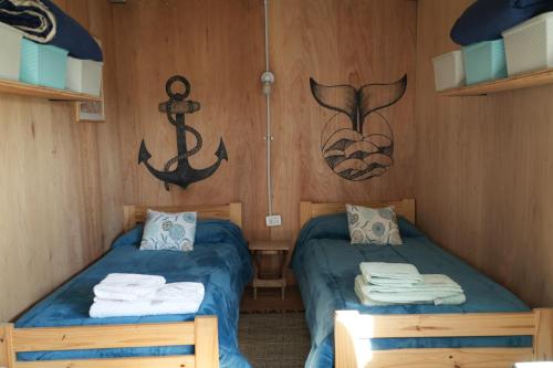 a cabin with two beds and an anchor on the wall at Casa container a 15km de Madryn in Puerto Madryn