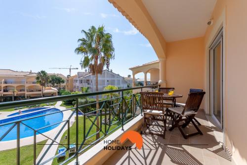 a balcony with a table and chairs and a swimming pool at #130 Praia Village by Home Holidays in Vilamoura