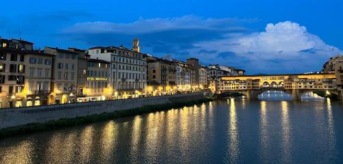 a bridge over a river in a city at night at Hotel Berchielli in Florence