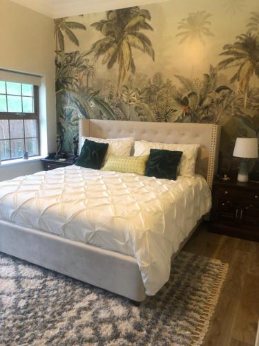 a large bed in a bedroom with a mural of palm trees at The Fairways, CastleBlayney in Castleblayney