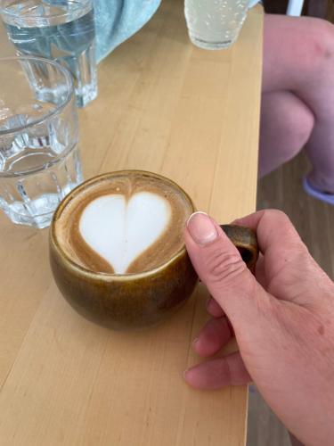 una persona sosteniendo una taza de café con un corazón en ella en The Fairways, CastleBlayney, en Castleblayney