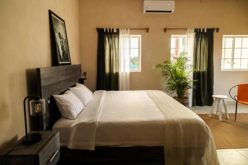a bedroom with a large bed and two windows at Gardenia Collective in Tulum