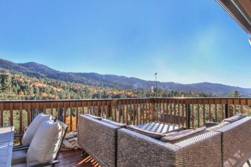 een balkon met rieten stoelen en uitzicht op de bergen bij Lazy Bear Lookout - hexagon cabin with resort views in Big Bear Lake