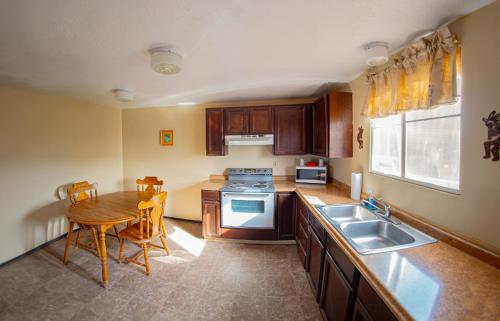 a kitchen with a table and a sink and a stove at Marble Canyon Lodge in Marble Canyon