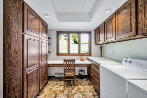 a kitchen with wooden cabinets and a table and a chair at Lakefront Home at Lake Winola, PA in Factoryville