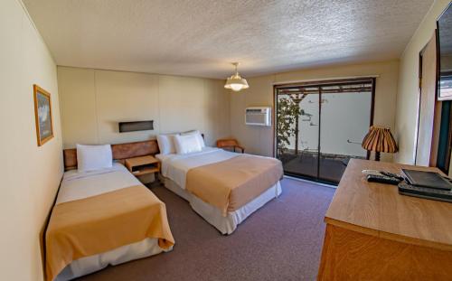 Marble CanyonにあるMarble Canyon Lodgeのベッド2台とデスクが備わるホテルルームです。