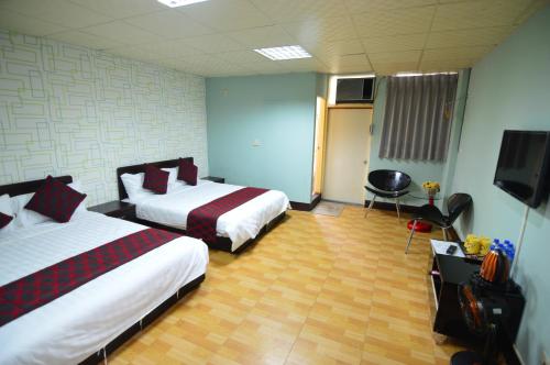 a hotel room with two beds and a flat screen tv at Dream Taiwan Homestay in Hualien City