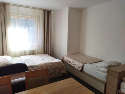 a hotel room with two beds and a window at Apartman Masa Kopaonik in Kopaonik