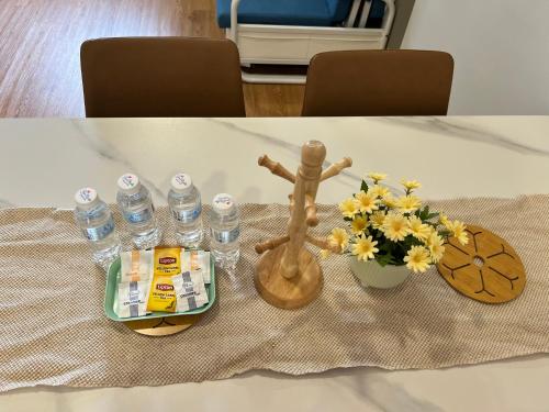 - une table avec des fleurs et des bouteilles d'eau dans l'établissement Chambers Couple studio 424, à Kuala Lumpur