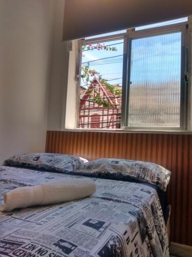 - une chambre avec un lit, une fenêtre et un couvre-lit dans l'établissement Mini estúdio Pão de Açúcar, à Rio de Janeiro