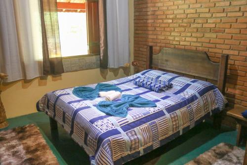 a bedroom with a bed with a blue and white blanket at Casa de campo, próximo ao parque Nacional do Itatiaia in Itamonte