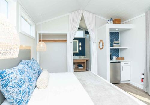a white bedroom with a bed and a kitchen at Sun Outdoors Sugarloaf Key in Summerland Key