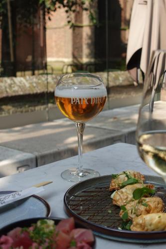 a glass of wine and a plate of food on a table at Herberg Sint Petrus in Hilvarenbeek
