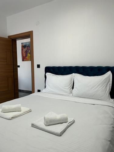a white bed with two towels on top of it at Star Apartments 1 in Novi Pazar