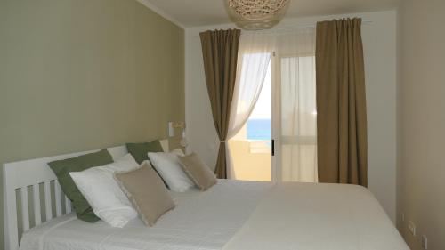 a bedroom with a bed and a window with the ocean at Blue Lagoon Apartment in Costa Calma