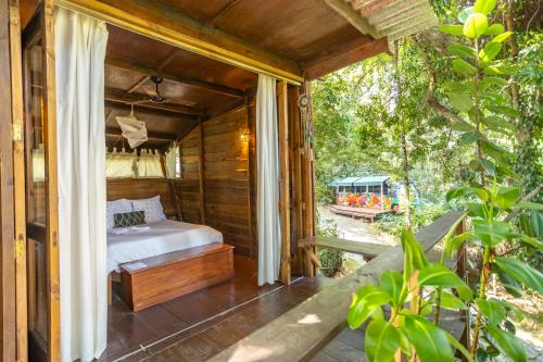 a bedroom in a house with a bed on a porch at Hostel Da Vila Ilhabela in Ilhabela
