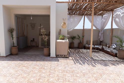 ein Wohnzimmer mit Topfpflanzen und ein Zimmer mit einer Couch in der Unterkunft DesArt in Tamraght Ouzdar