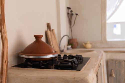 een pot op een fornuis in een keuken bij DesArt in Tamraght Ouzdar