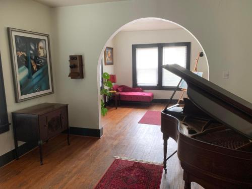 a living room with a piano and a pink couch at Dr. Yaple's Art Deco House in Lafayette