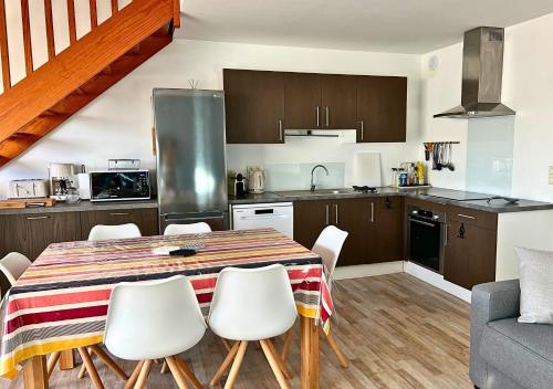 une cuisine et une salle à manger avec une table et des chaises dans l'établissement Duplex Gardenia - Lumineux & Central, à Biscarrosse