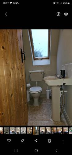 łazienka z toaletą, umywalką i oknem w obiekcie Longford Holiday Blue Sky Self Catering Cottage 