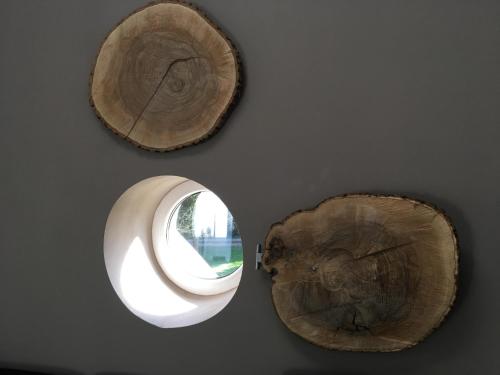 two wooden logs and a window on a wall at Le gîte du Bois de Loo in Attert