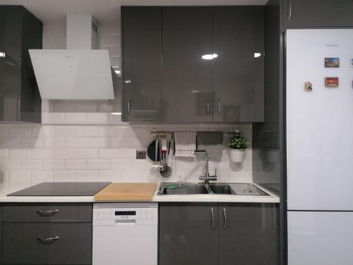 uma cozinha com um lavatório e um frigorífico branco em Habitaciones Torremolinos em Torremolinos