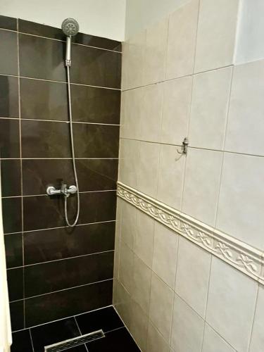 y baño con ducha y azulejos blancos y negros. en Urban Oasis 1, en Tirana