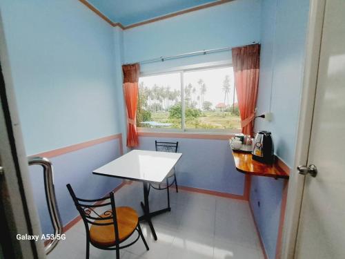a small room with a table and a window at Peace Lanta Mansion in Ko Lanta