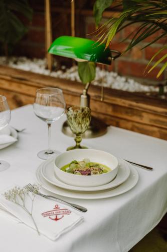 a table with a plate of food on a table with wine glasses at Apartamenty Kapitańskie - Pływające in Oława