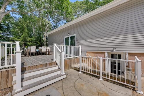 a home with a large deck and a house at Hampton Bays Retreat Walk to Squires Beach! in Hampton Bays