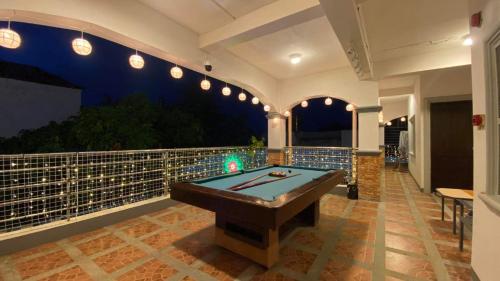 Habitación con balcón con mesa de billar. en villa paguio hot spring resort, en Calambá