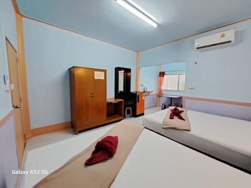 a bedroom with two beds with red pillows on them at Peace Lanta Mansion in Ko Lanta