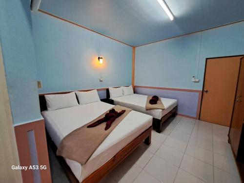 a bedroom with two beds with towels on them at Peace Lanta Mansion in Ko Lanta