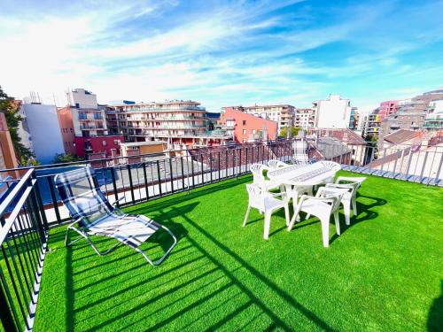 a balcony with a table and chairs on the grass at BUDAPEST DOWNTOWN RESIDENCES LEO - AC, ELEVATOR, TERRACE in Budapest