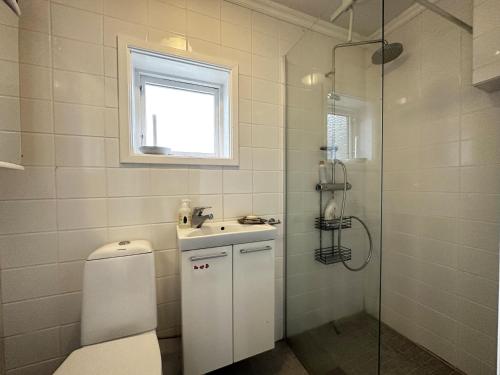 e bagno con servizi igienici, lavandino e doccia. di Very nice villa in northwestern Orust a Henån