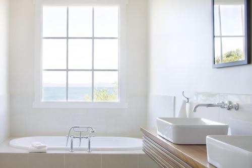 a bath tub sitting next to a window in a bathroom at Piermont Retreat in Swansea