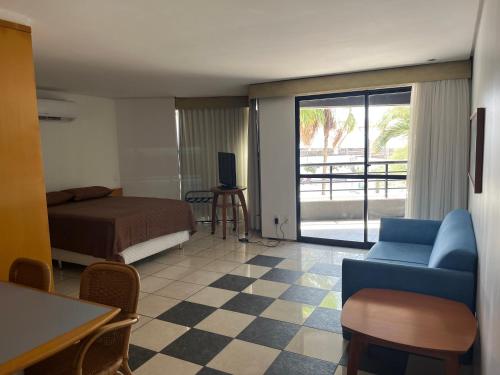 - une chambre avec un lit, un canapé et une télévision dans l'établissement Flat Iate Plaza, à Fortaleza