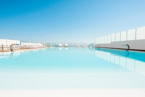 una piscina de agua azul en un edificio en Marina di Petrolo Apartments, en Castellammare del Golfo