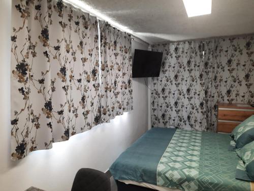 1 dormitorio con 1 cama y cortinas con flores en Studio Primani en Sečovlje